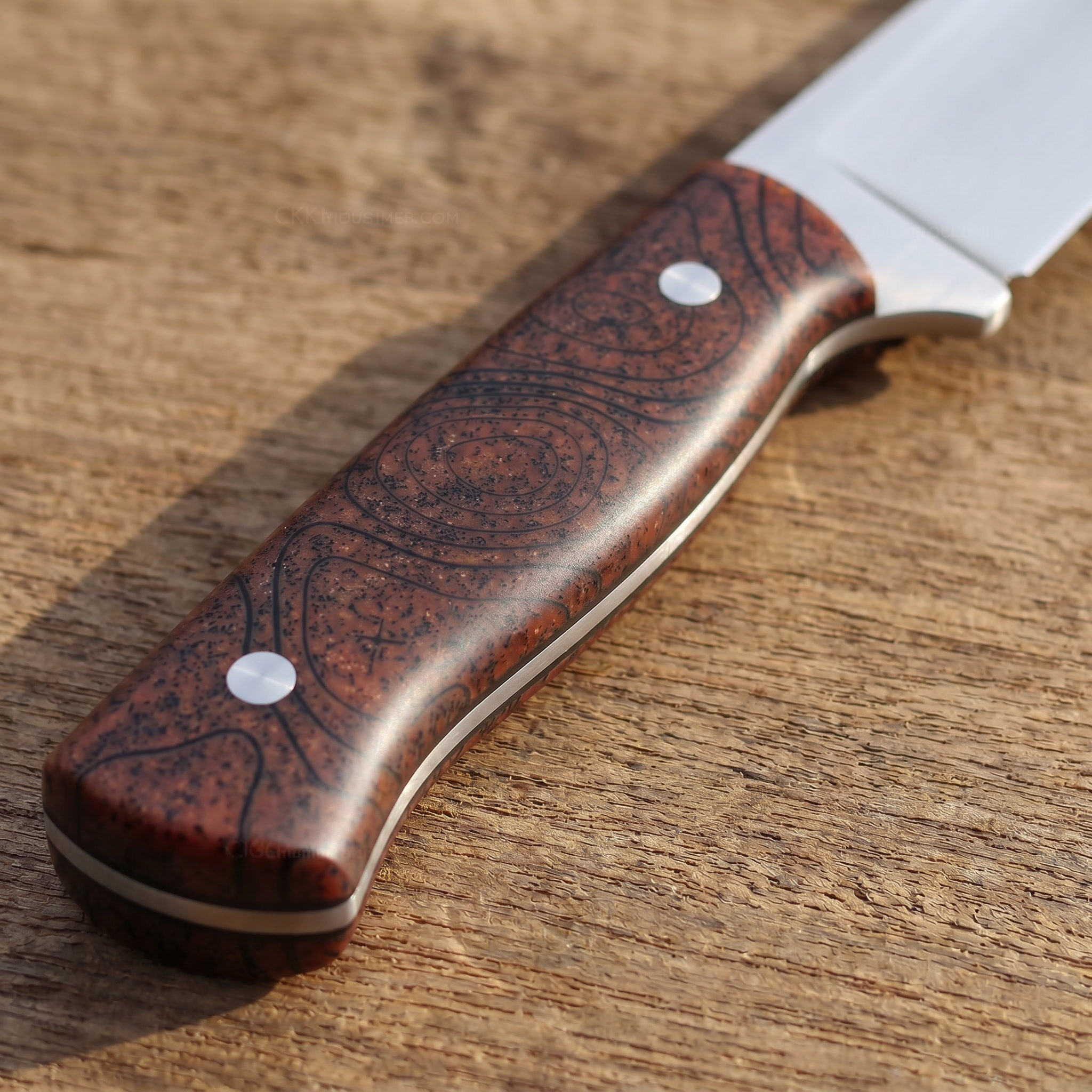 Knife handle made of GripX Copper Metallic Handle Scales on wooden surface