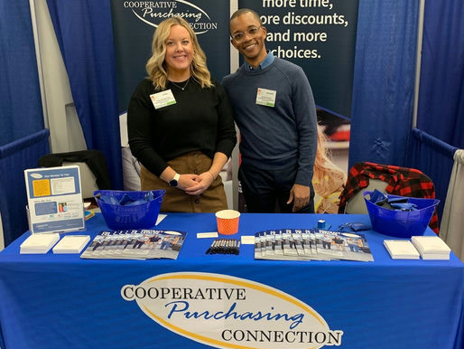 Two people at a table at a trade show.