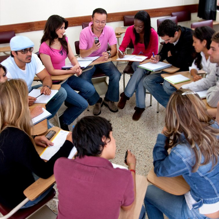 Students working together in a circle at desks.