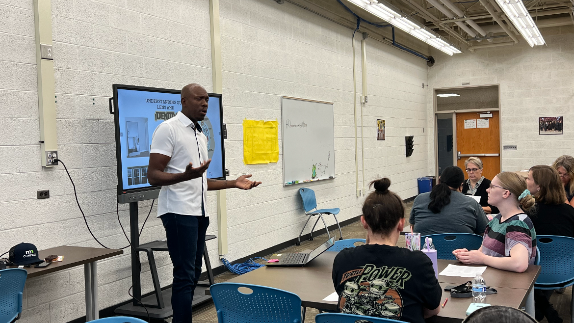 Derek Francis presenting to a group of people in a classroom.