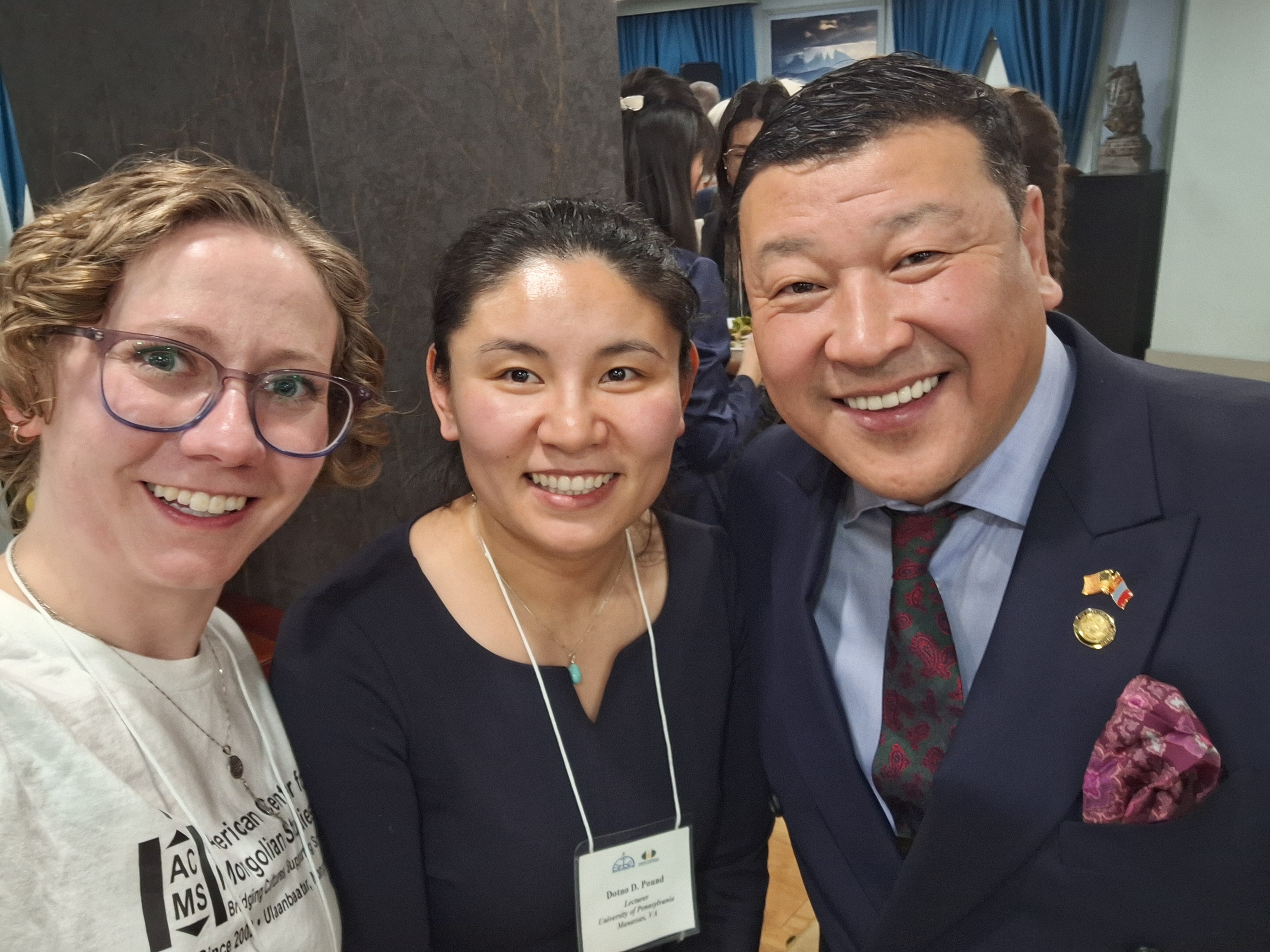 Three people posed together. From left to right: ACMS U.S. Director Maggie Lindrooth, a lecturer at the conference, and Ambassador Batbayar Ulziidelger.