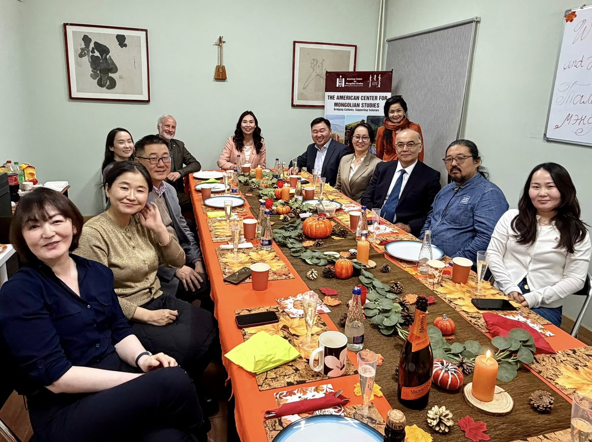 A group of people sitting in rows in an auditorium looking at the camera and smiling