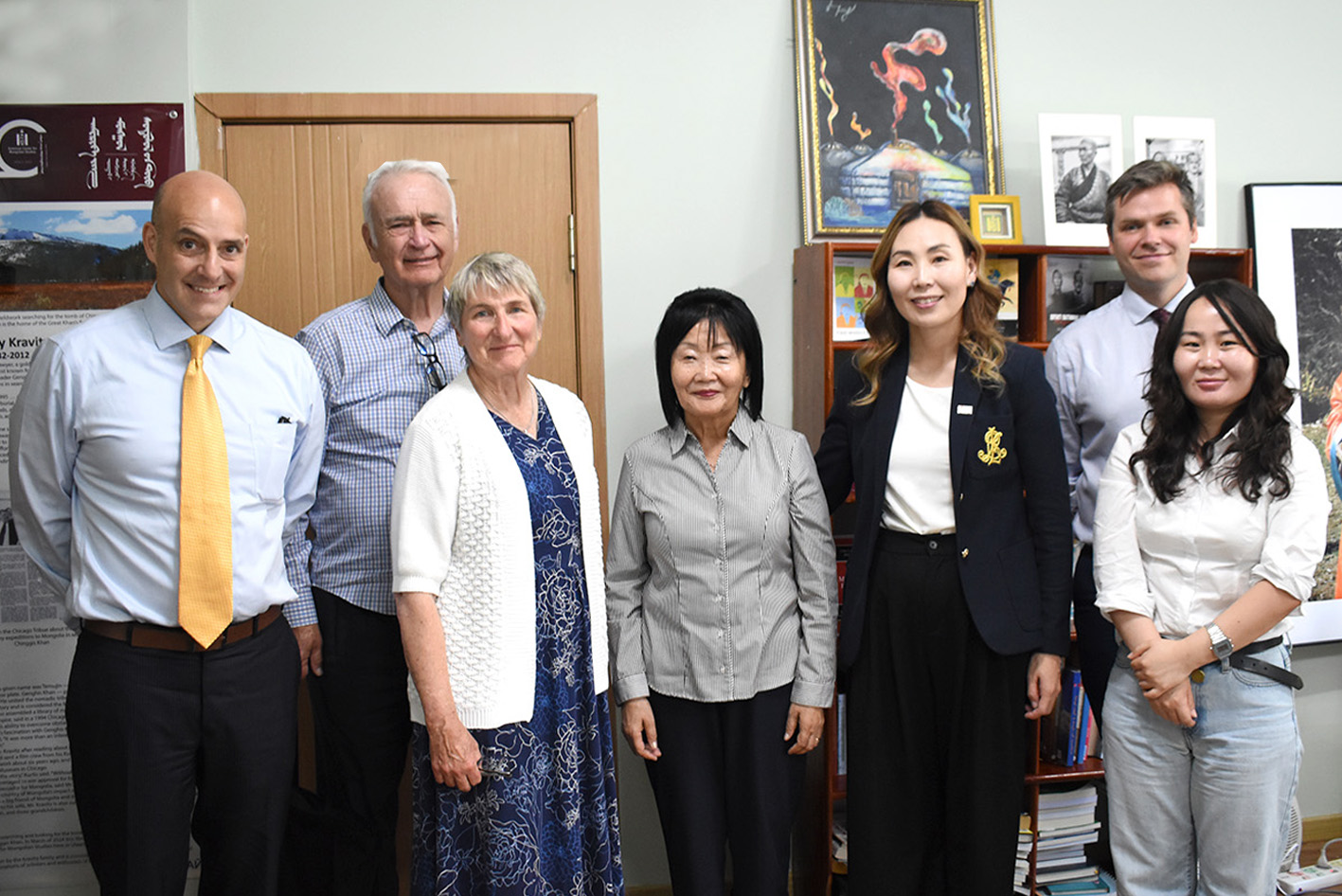 A group of four white Americans (three men, one woman) and three Mongolian women stand together and smile for the camera.
