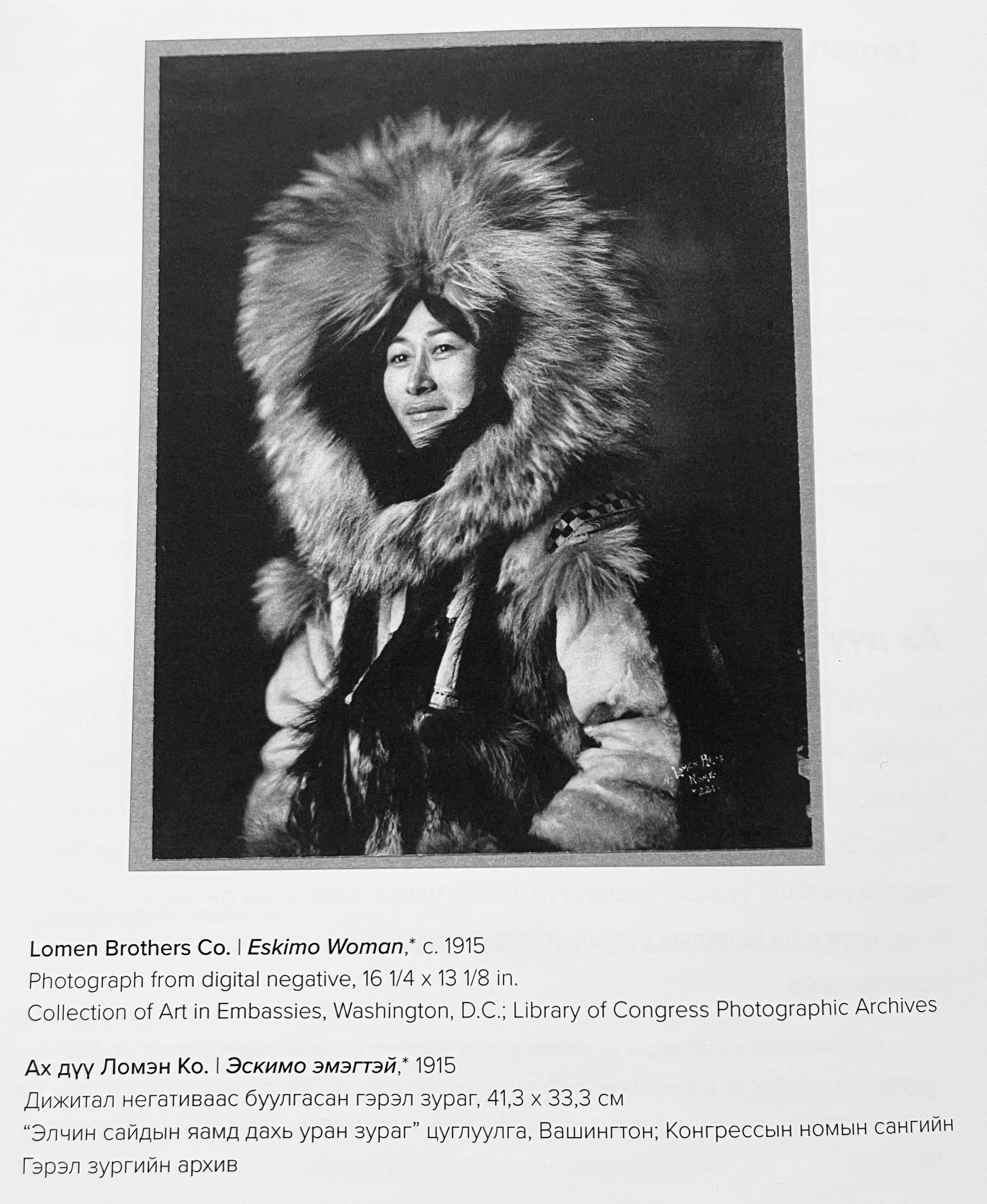 A black and white photo of an Alaskan Native woman wearing a coat with a large fur hood.