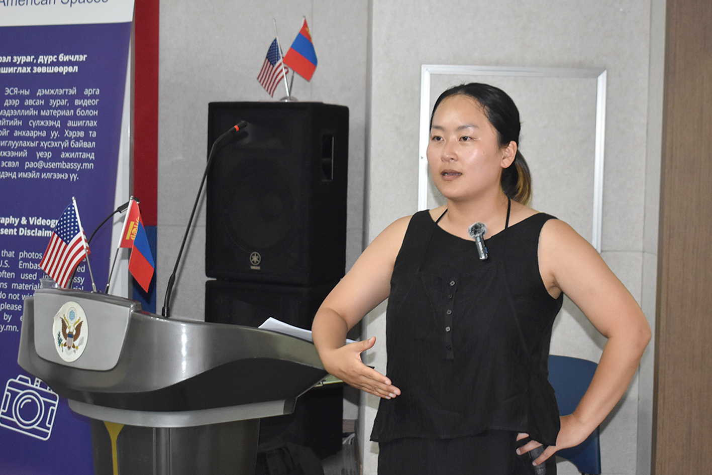 Nari Lee, a South Korean woman in her thirties, stands at a podium giving a lecture on her research.