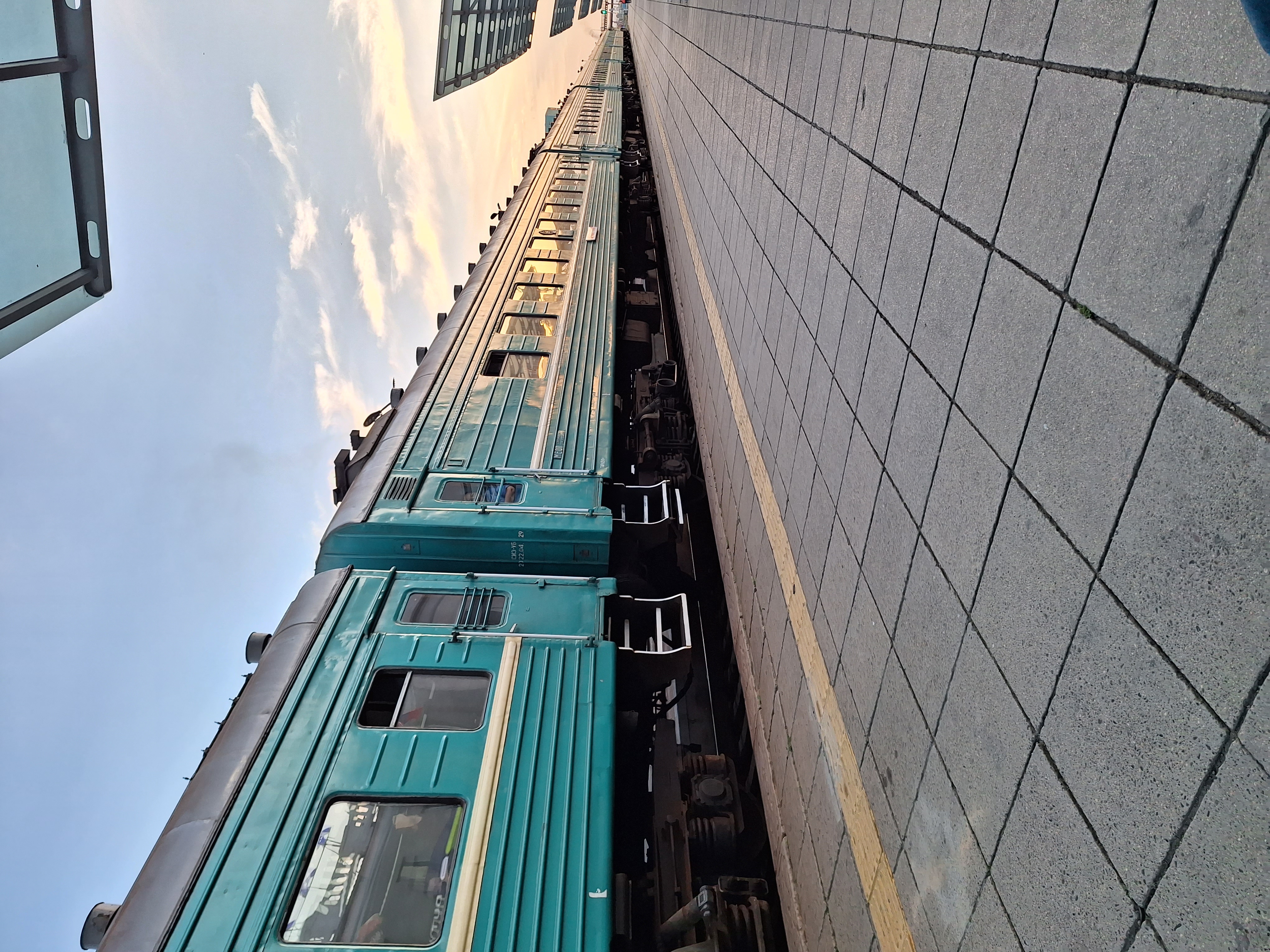 A blue train parked at a station in Mongolia.