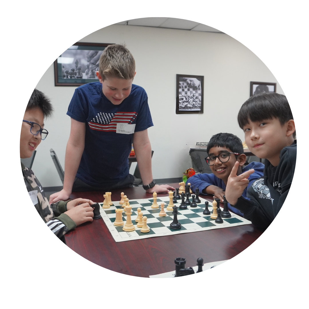 boys smiling over chess pieces