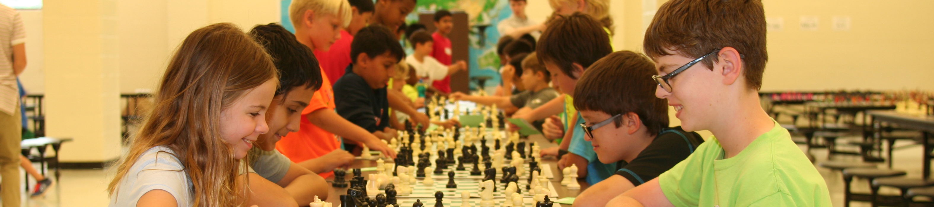 Kids smiling and playing chess