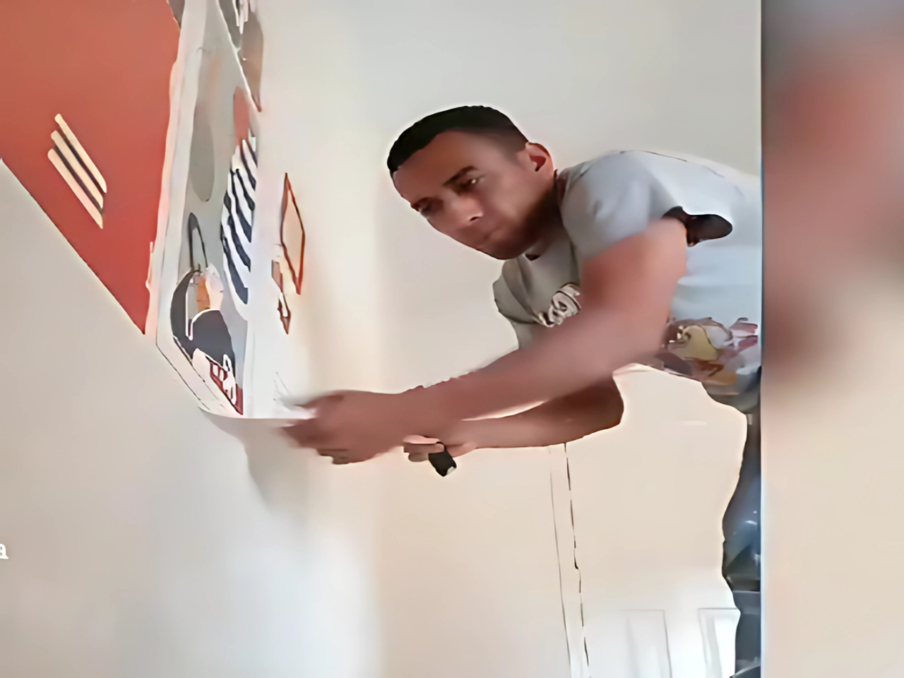 painter jacob removing wallpaper from a bedroom wall