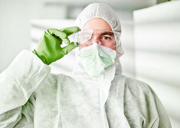 Photo of a person wearing a full-body protective suit to prevent cross-contamination