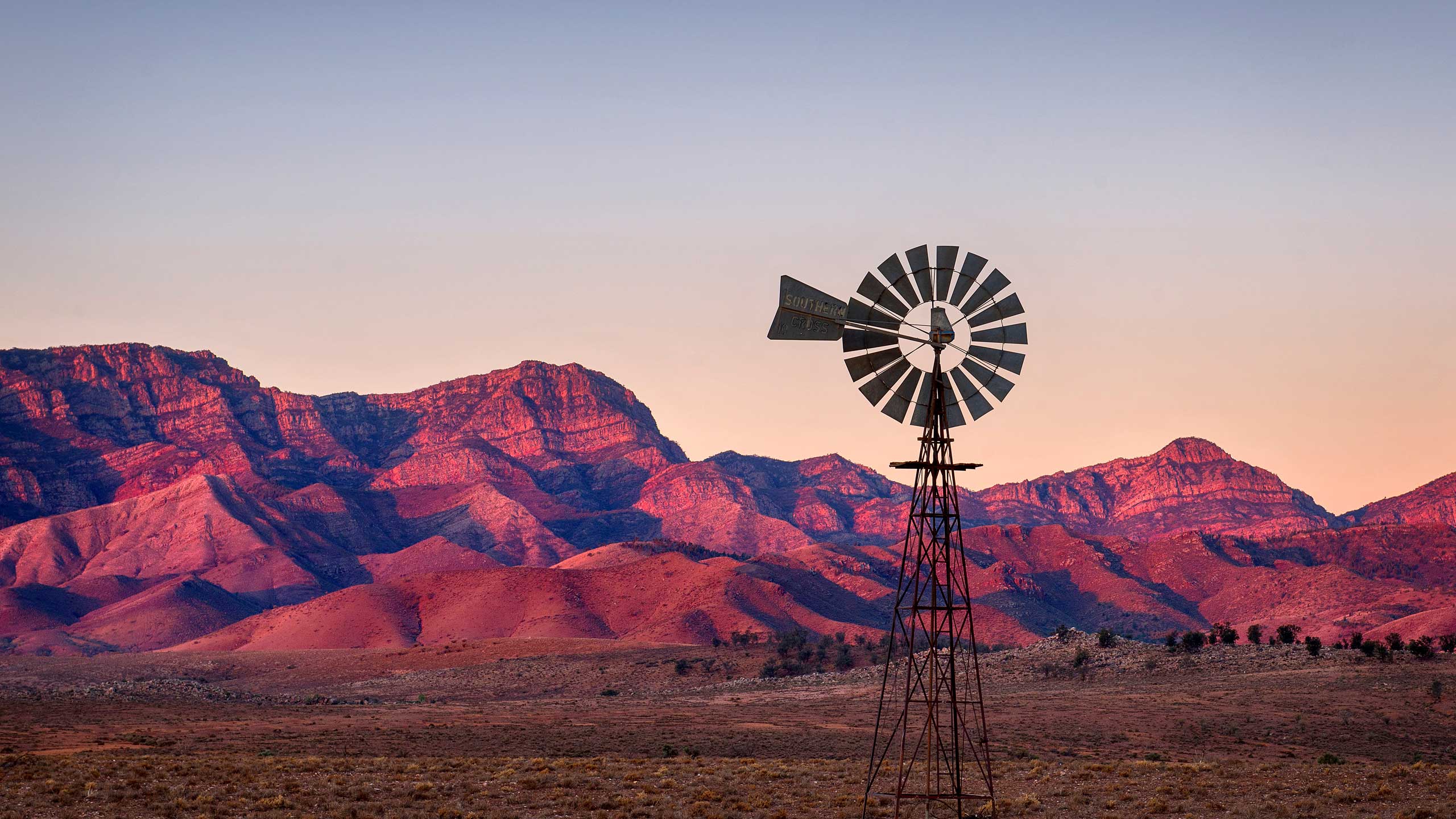 Windmill on a red rock mountain range background