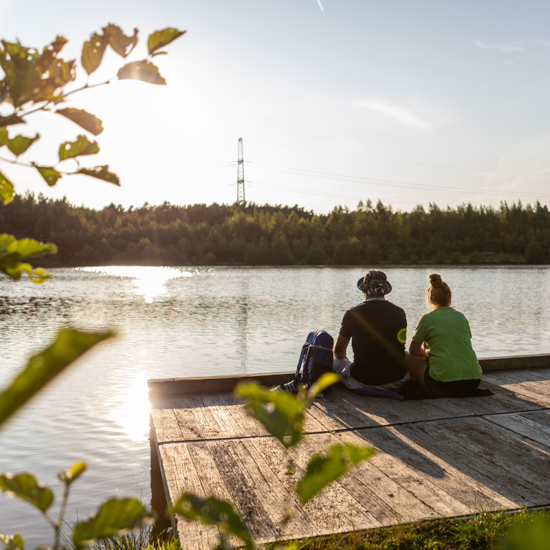 twee mensen die op een platform aan het water zitten