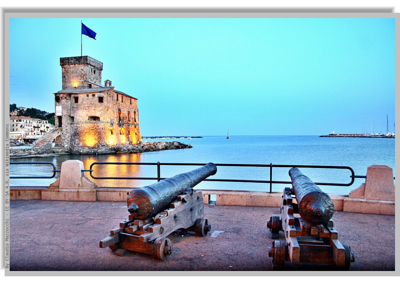 Promenade with ancient medieval cannons along the seafront of the Bay of Rapallo, with in the background the Castle from the 1500s, on a rock on the sea