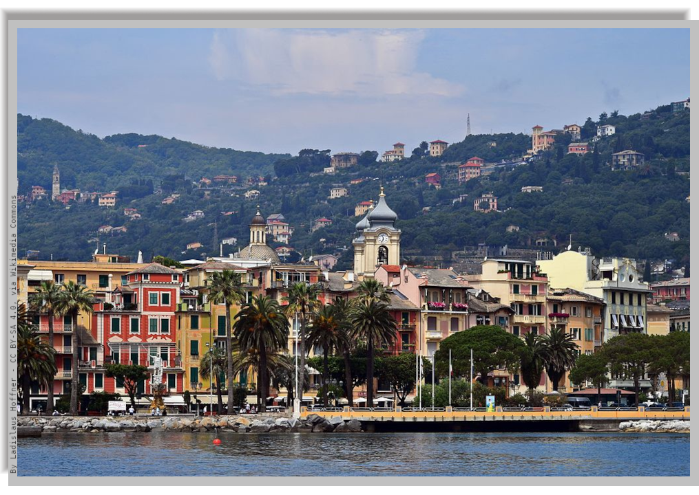 The coastline of Santa Margherita Ligure viewed from the sea, with its palms, coloured house facades and green hills behind