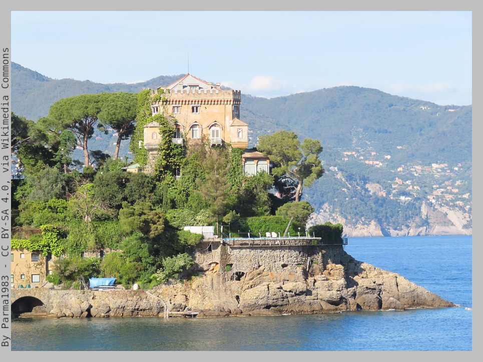 Castle on a cliff by the sea surrounded by maritime pine trees and green vegetation