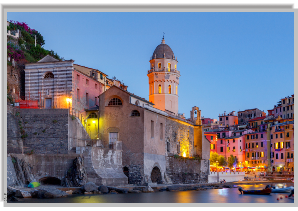 The church of Vernazza and its belltower, located on a rock by the sea, illuminated in the evening