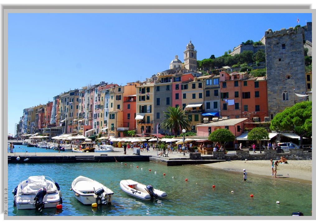 Houses lined up along the seafront, with promenades and boats bobbing in the water in front of the beach
