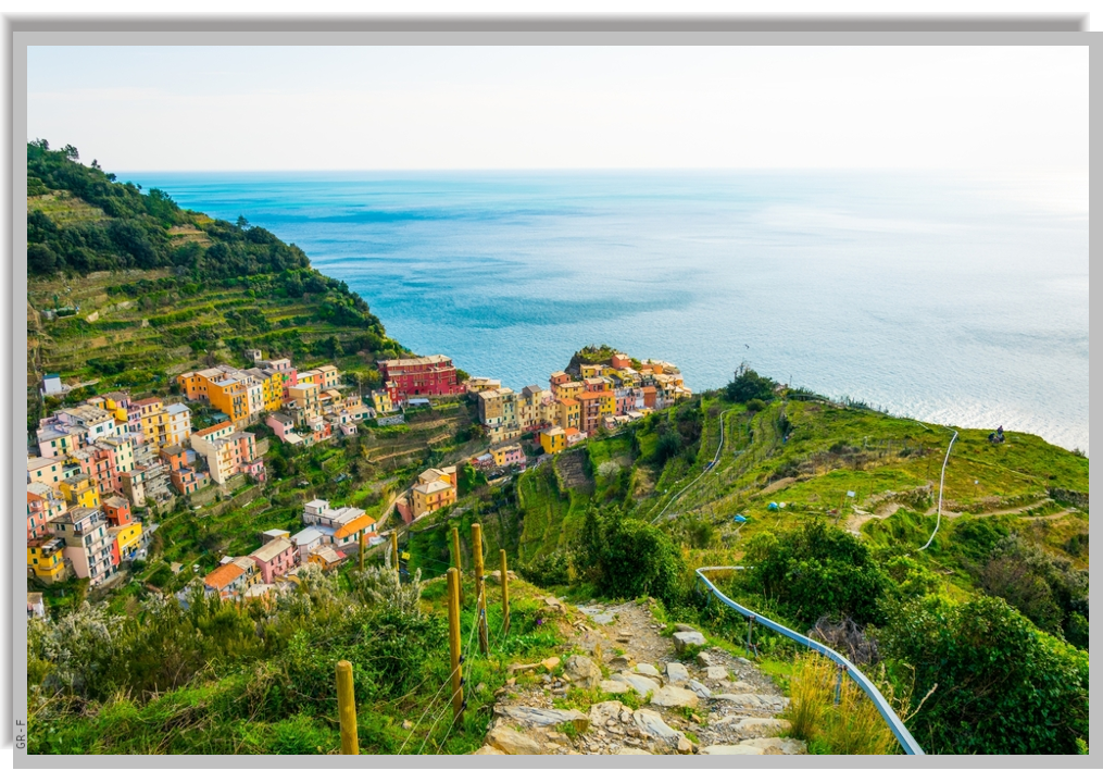 A trail on the green hills of Manarola leads down towards the village