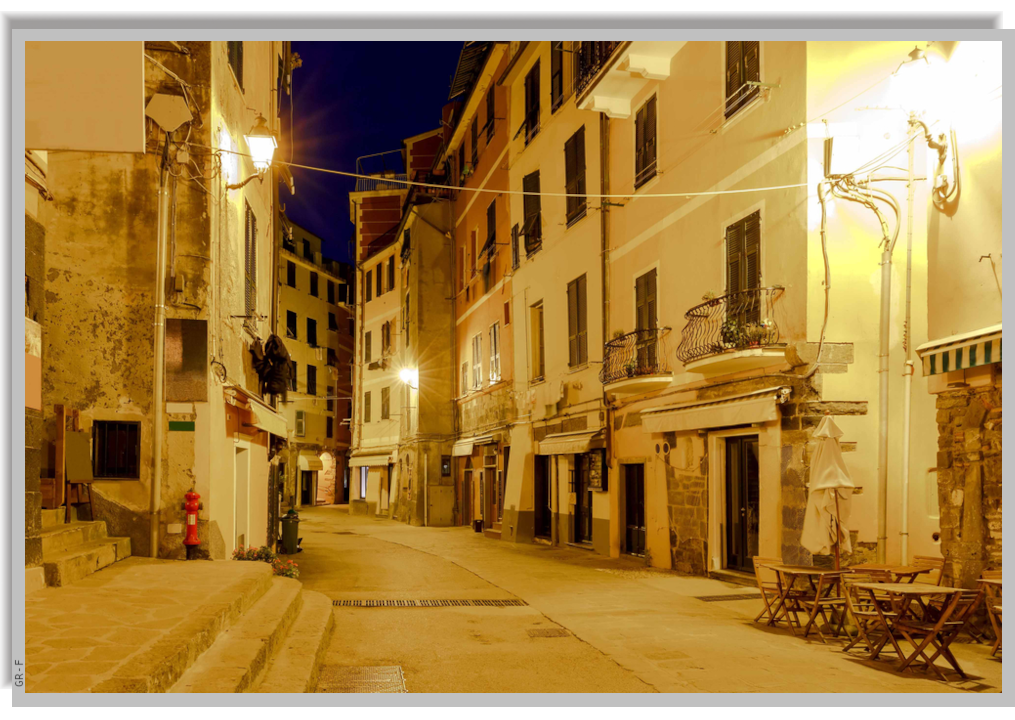 A street of the village of Vernazza illuminated by streetlights at night