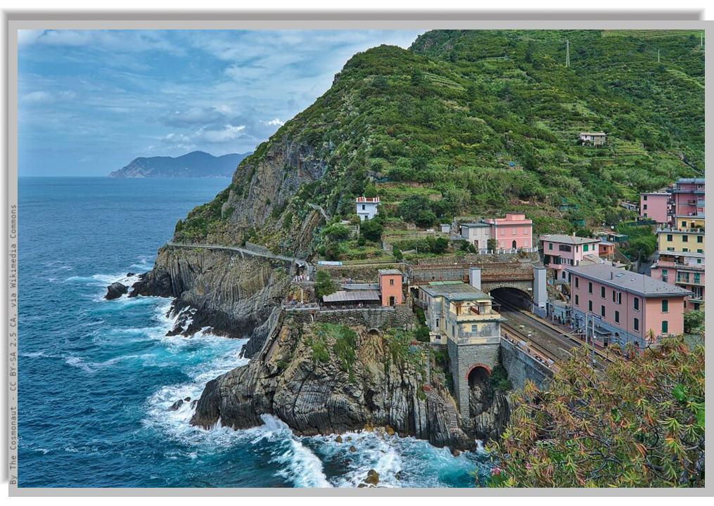the coastal railroad and the station of Riomaggiore right outside a tunnel in a green hill. Beside, the sea and the rocky coastline