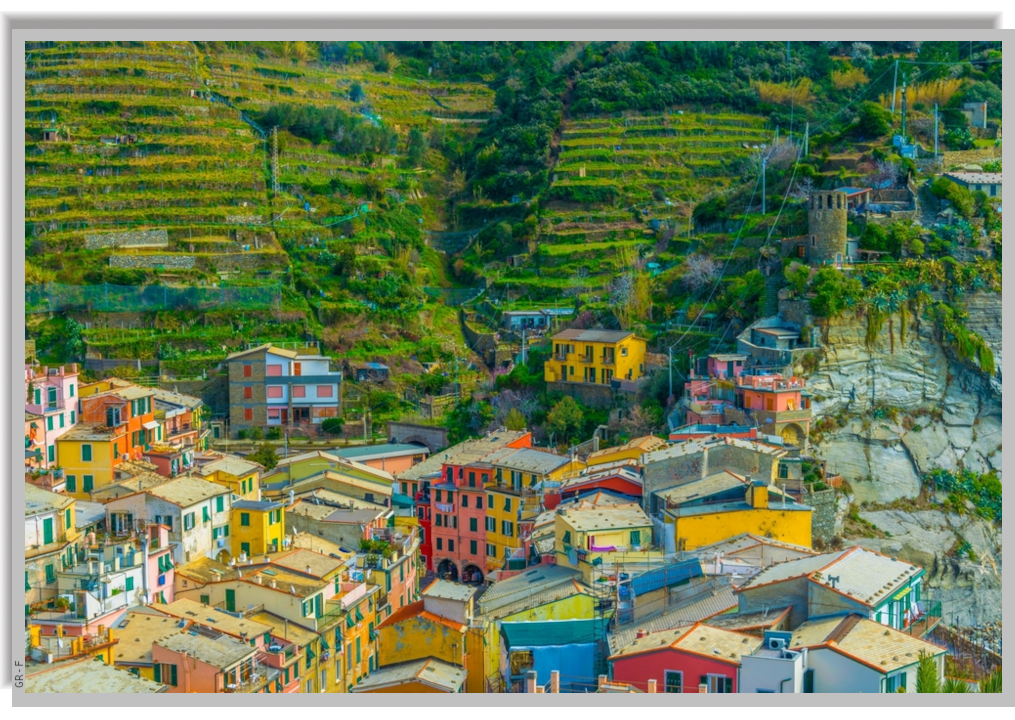 The colorful houses of the village and the green cultivated hills surrounding
