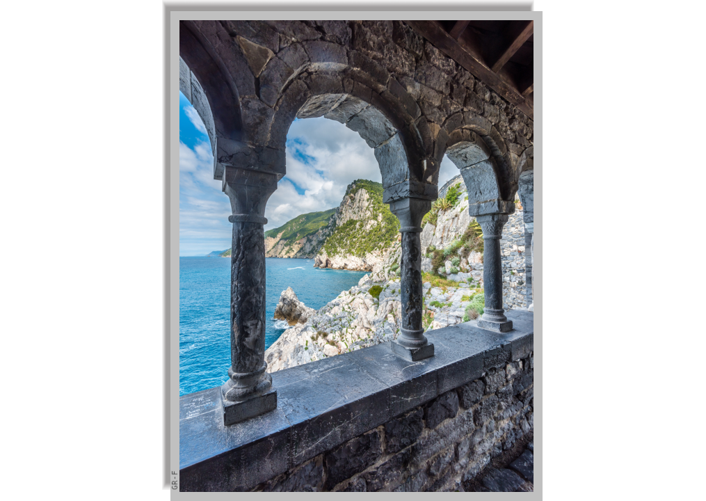 View of the coastline through the arched colonnaded window of medieval ruins