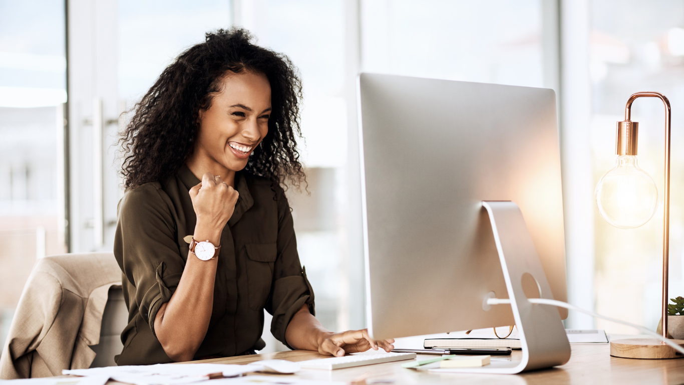 Female fist pumping in front of computer Rewarding career