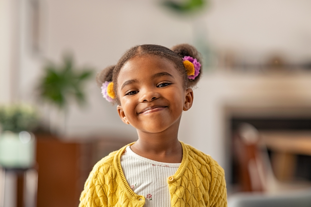 African American girl smiling in yellow sweater full of confidence