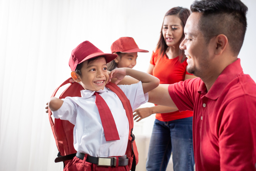 boy getting ready for school smiling at dad
