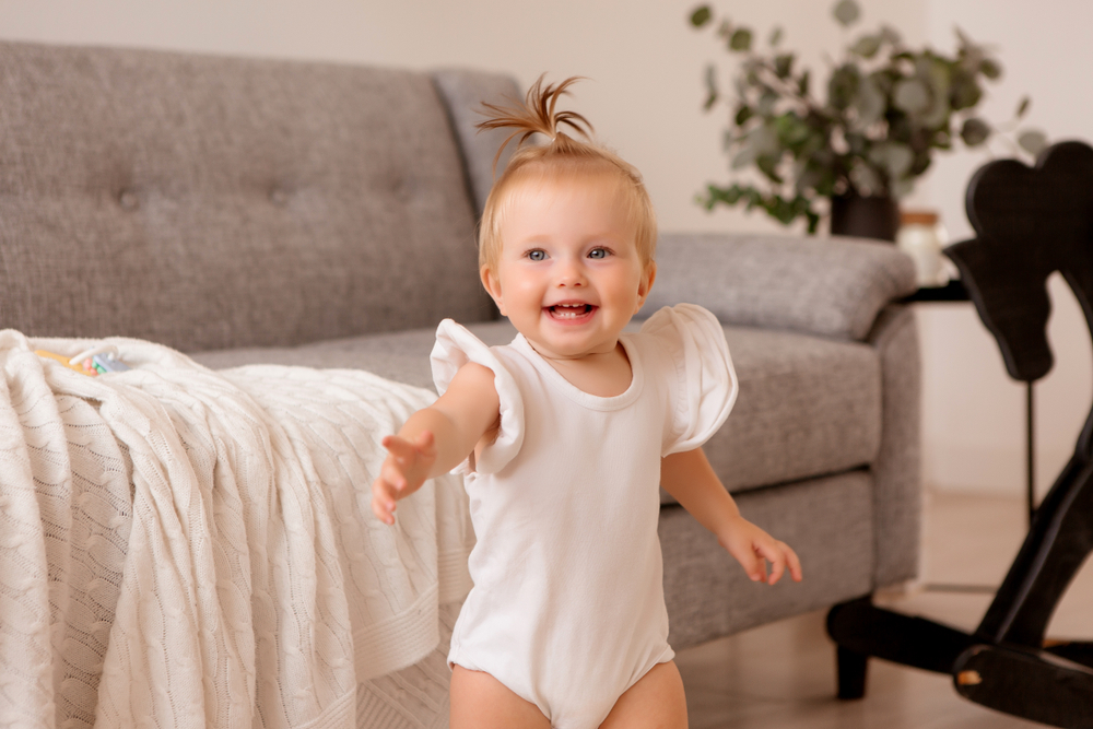 Young toddler smiling in white onesie