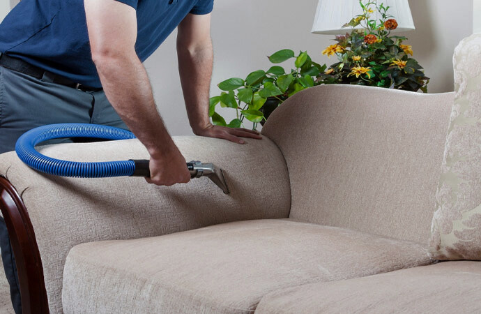 Technician deep-cleaning a fabric sofa