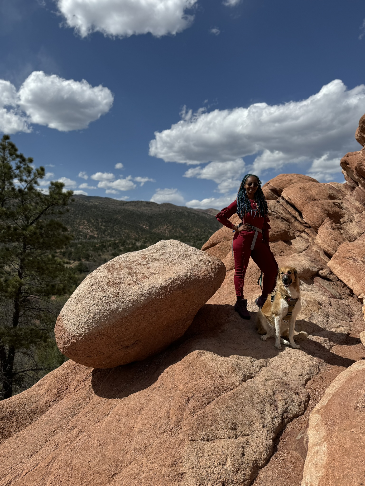 Natalee hiking with service dog, blue sky and sandstone.