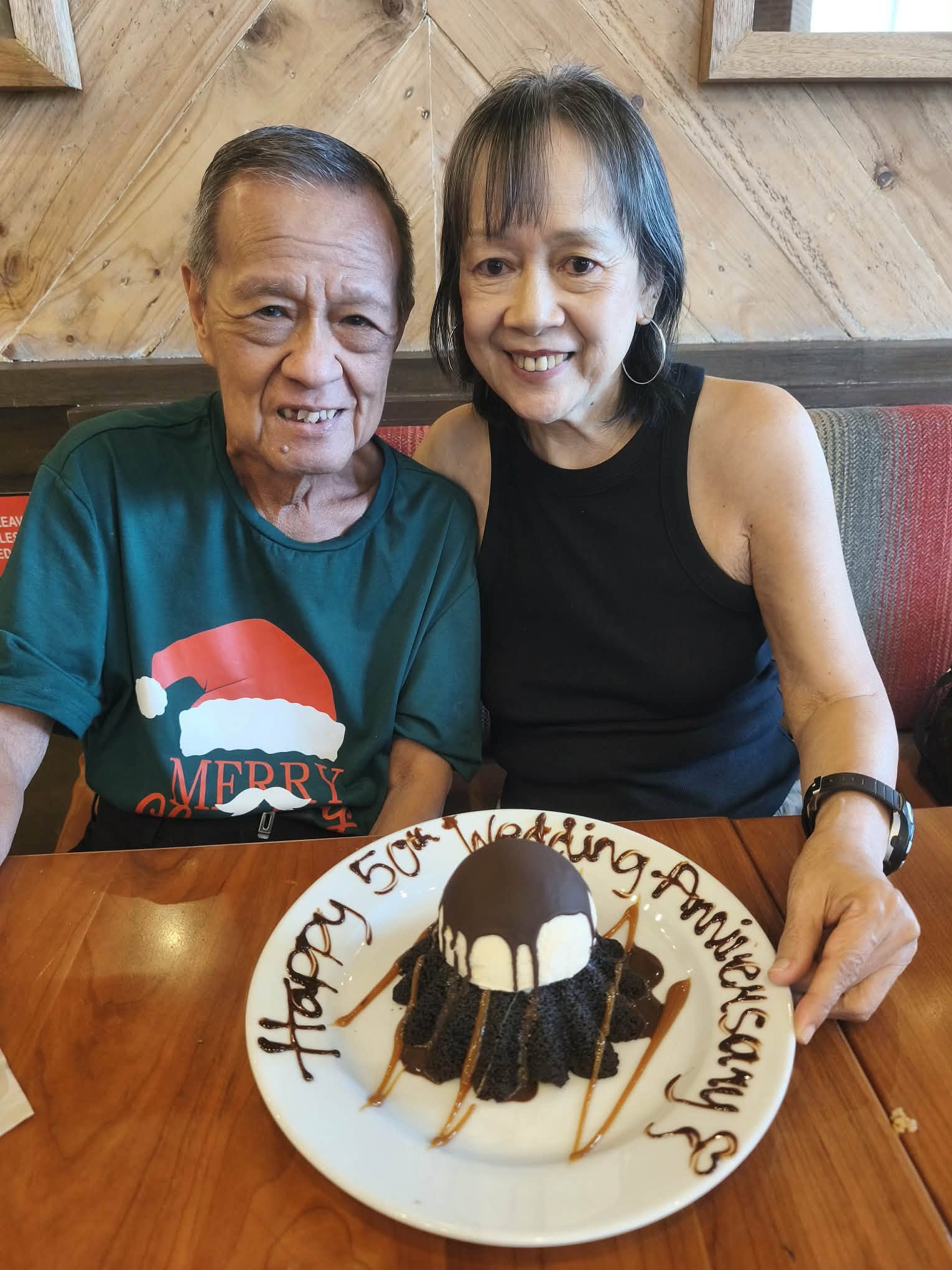 Rey and Sarah Mangio celebrating their 50th wedding anniversary together with a cake.