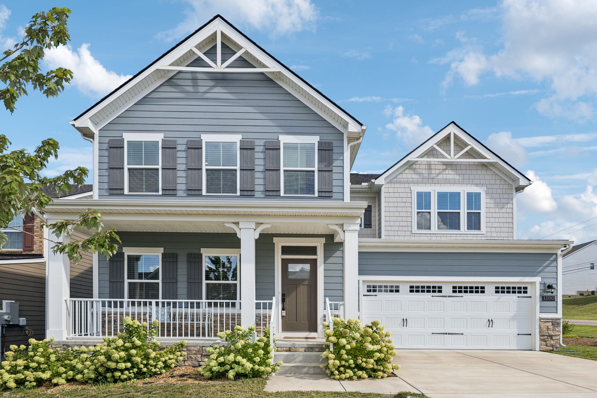 Two-story gray and white smart home with covered front porch, manicured lawn, and modern exterior design located at 1100 Marchand Dr in Smyrna, TN.