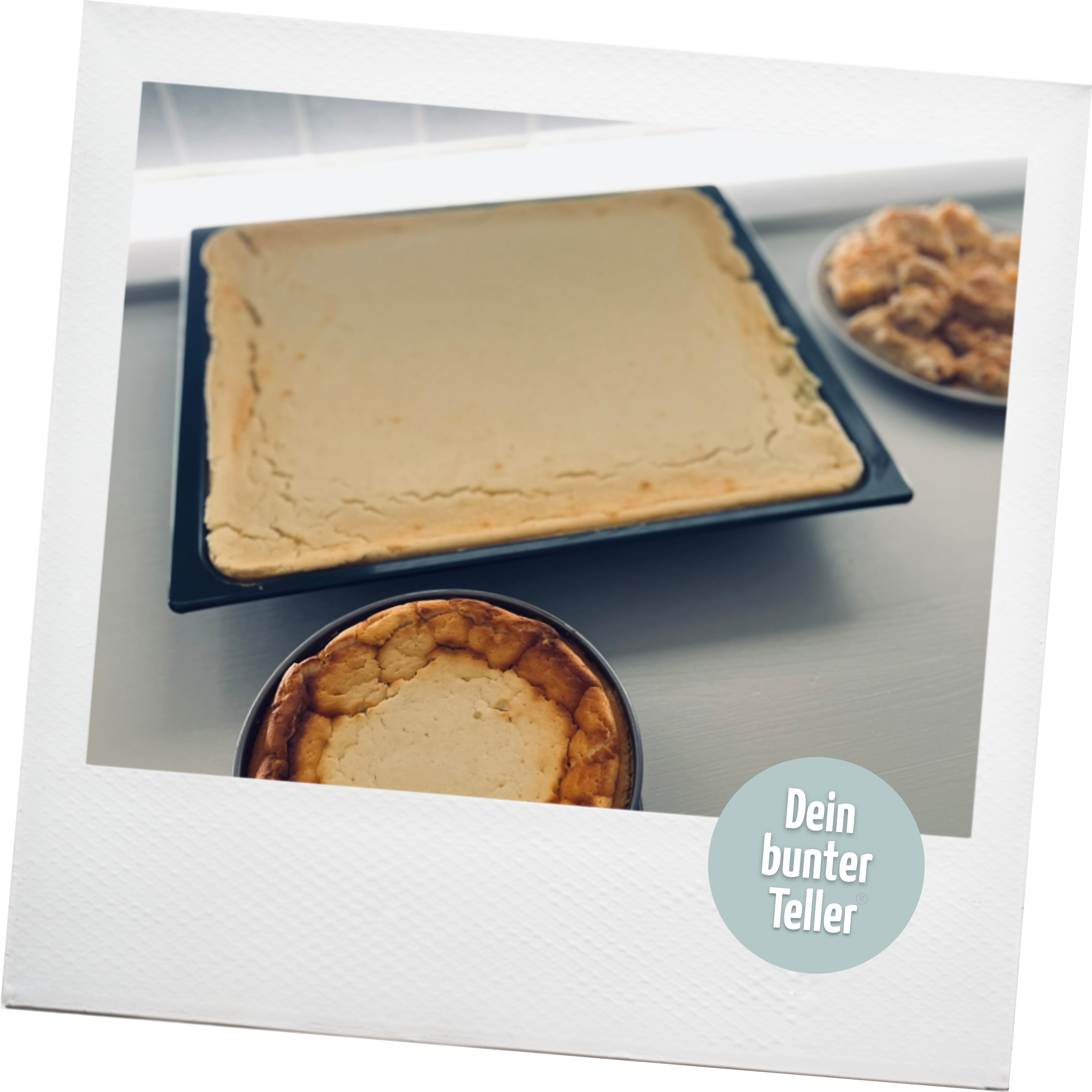 Ein Polaroid, auf dem ein Backblech und eine Sprinform mit frisch gebackenem Käsekuchen abgebildet ist. Außerdem ist das Logo von "Dein bunter Teller" abgebildet.