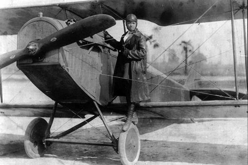 Bessie Coleman with her Curtiss JN-4 “Jennie” in her custom-designed flying suit, 1924. Photo courtesy Smithsonian Magazine.
