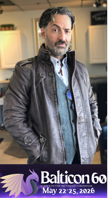 Jim looking very handsome over a banner with the Balticon logo advertising that the con will take place May 22-25 in Balticon, Maryland