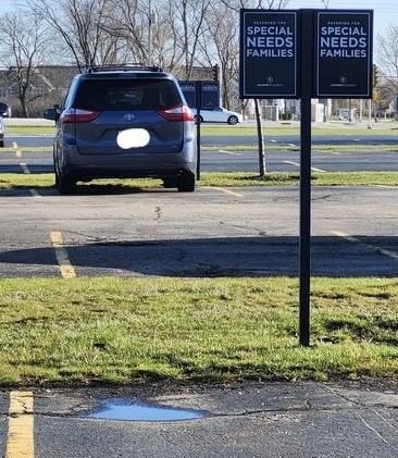 Parking lot with car and sign that reads Reserved for Special Needs Families