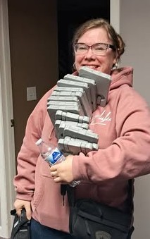 Nettamara holding a stack of Curriculum and Bible Audio Cartridges