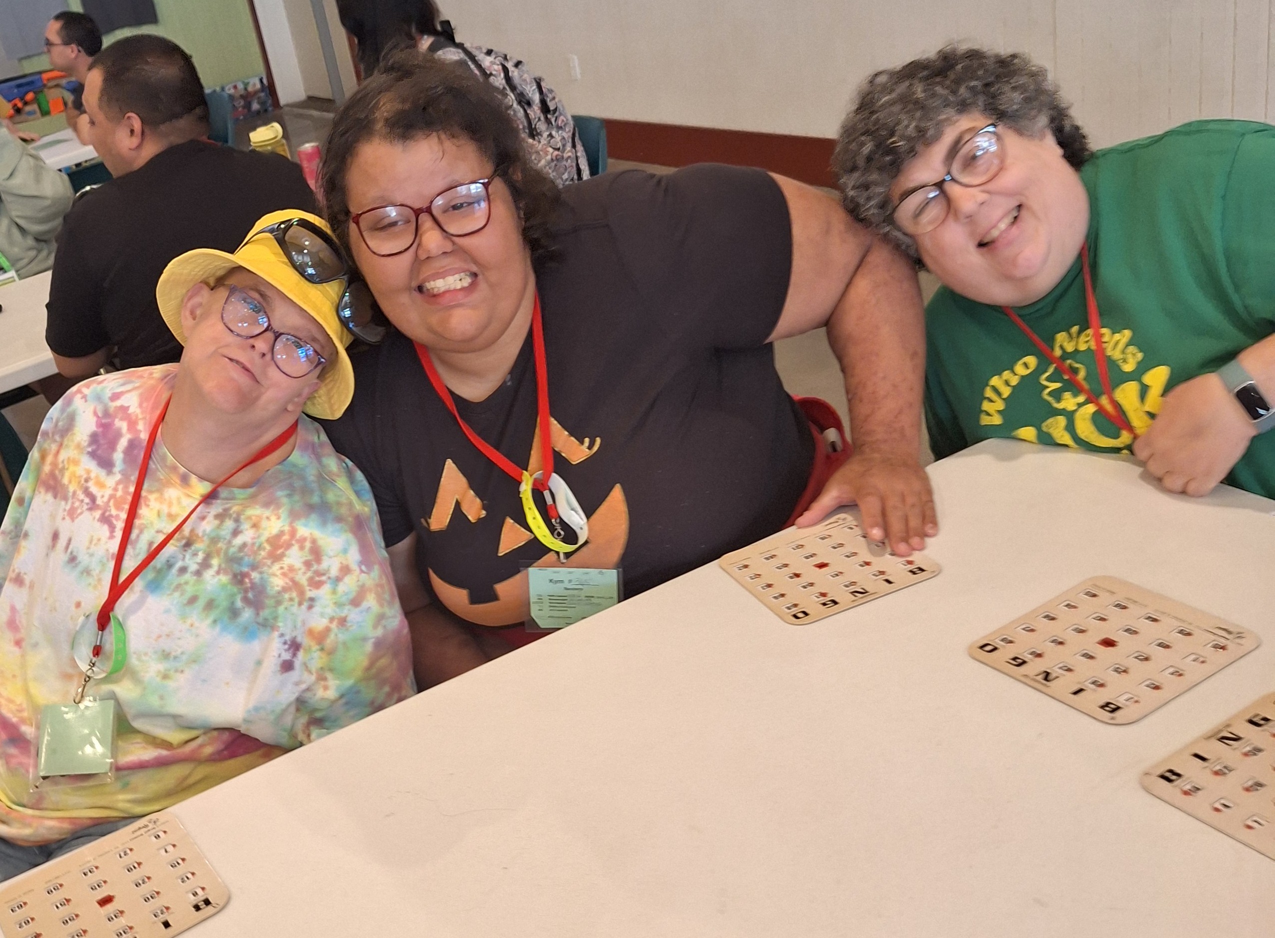 three woman smiling while playing bingo together