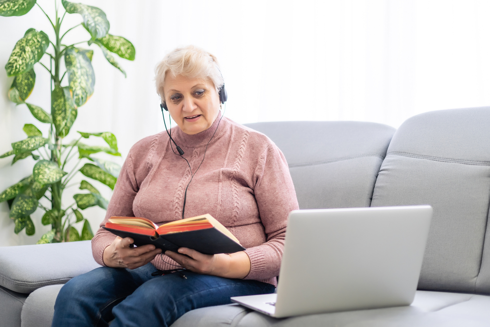 Woman with a bible and laptop wearing headphones and a microphone