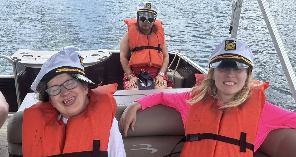 three girls in a boat all wearing captain hats