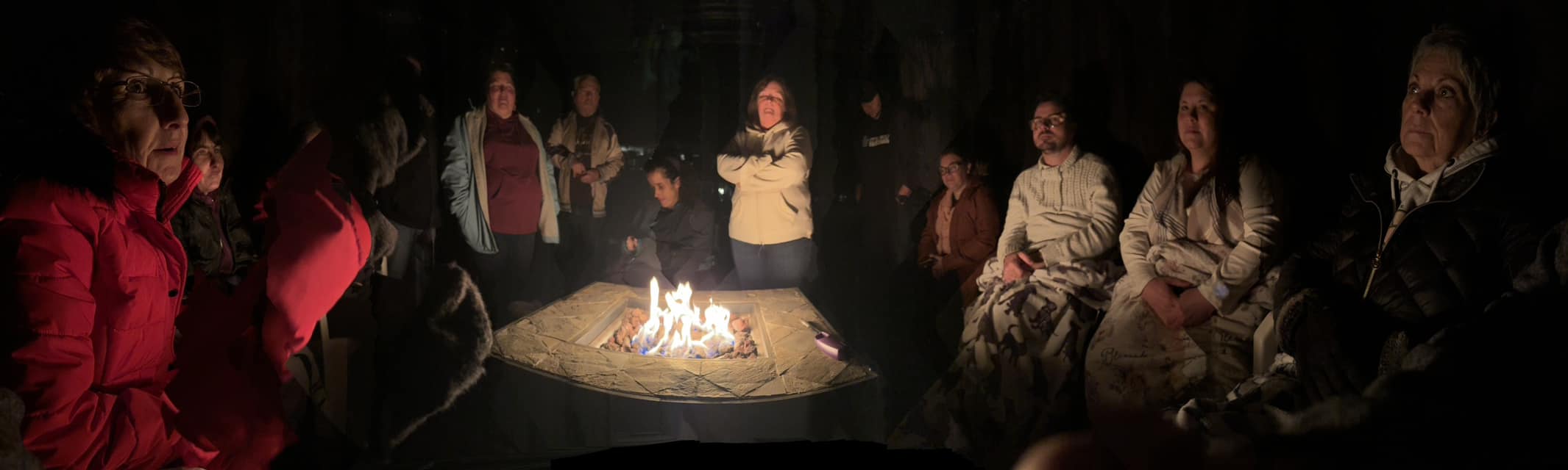 Group sitting around the warm glowing campfire