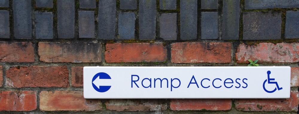 Sign on a wall showing Ramp Access to the left