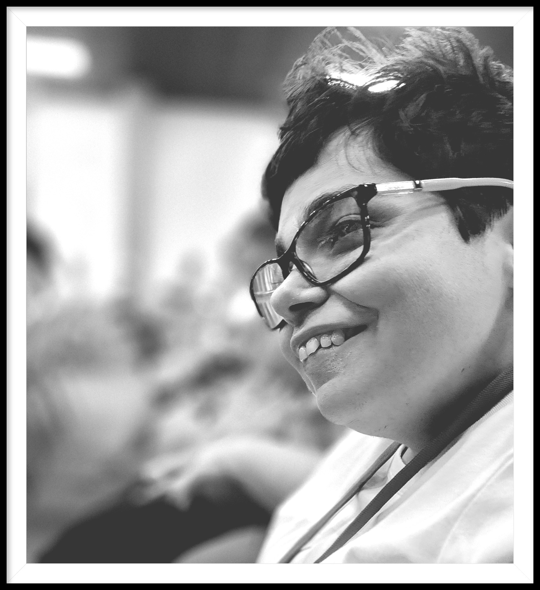 A woman smiling in a crowd full of people.