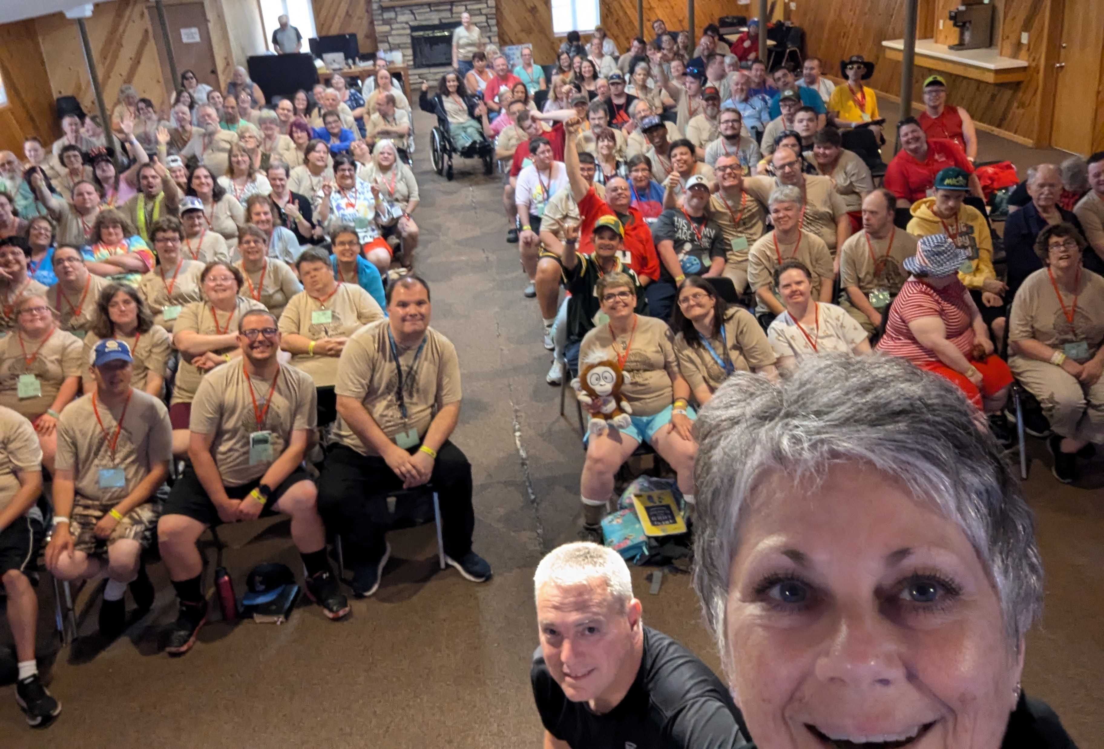 Executive Director Debbie Chivers taking a self with a large room full of people behind her