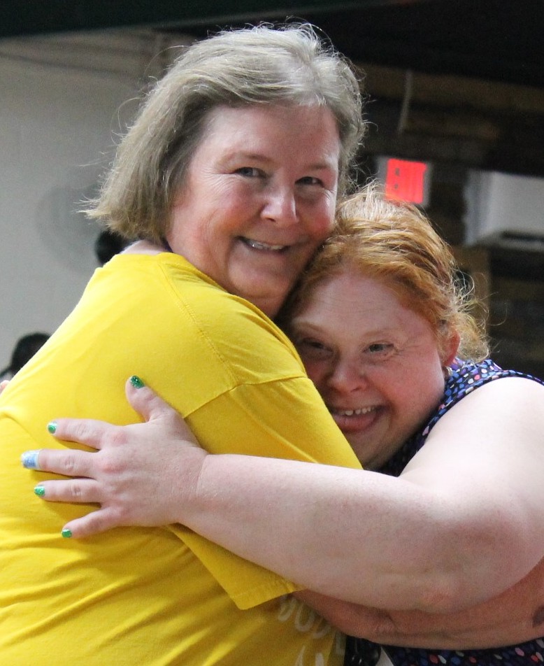 Charlene and friend (guest particpant) hugging and smiling