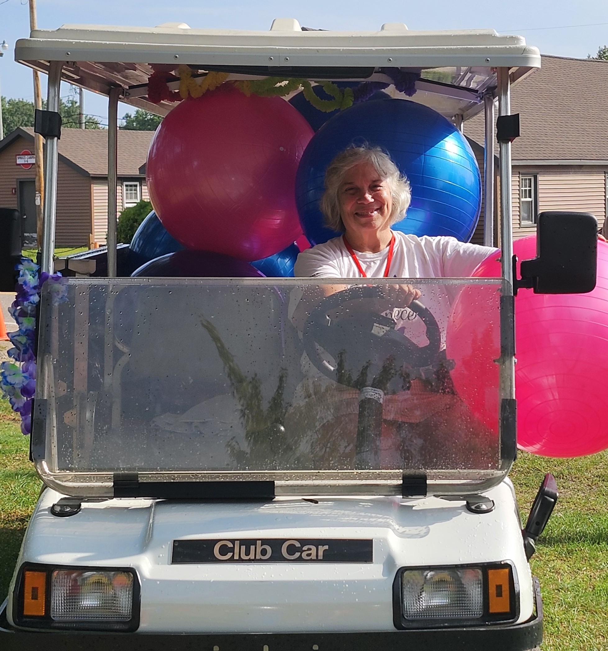 Cindy Maher in a golf cart filled with giant inflated activity balls