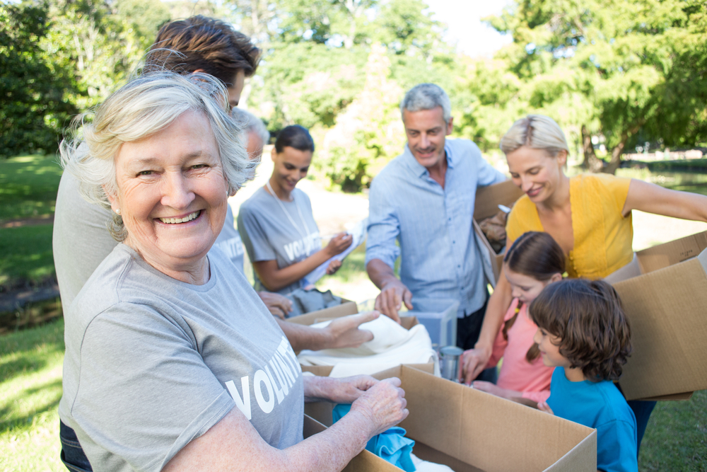 A woman giving away boxed items to a group of people