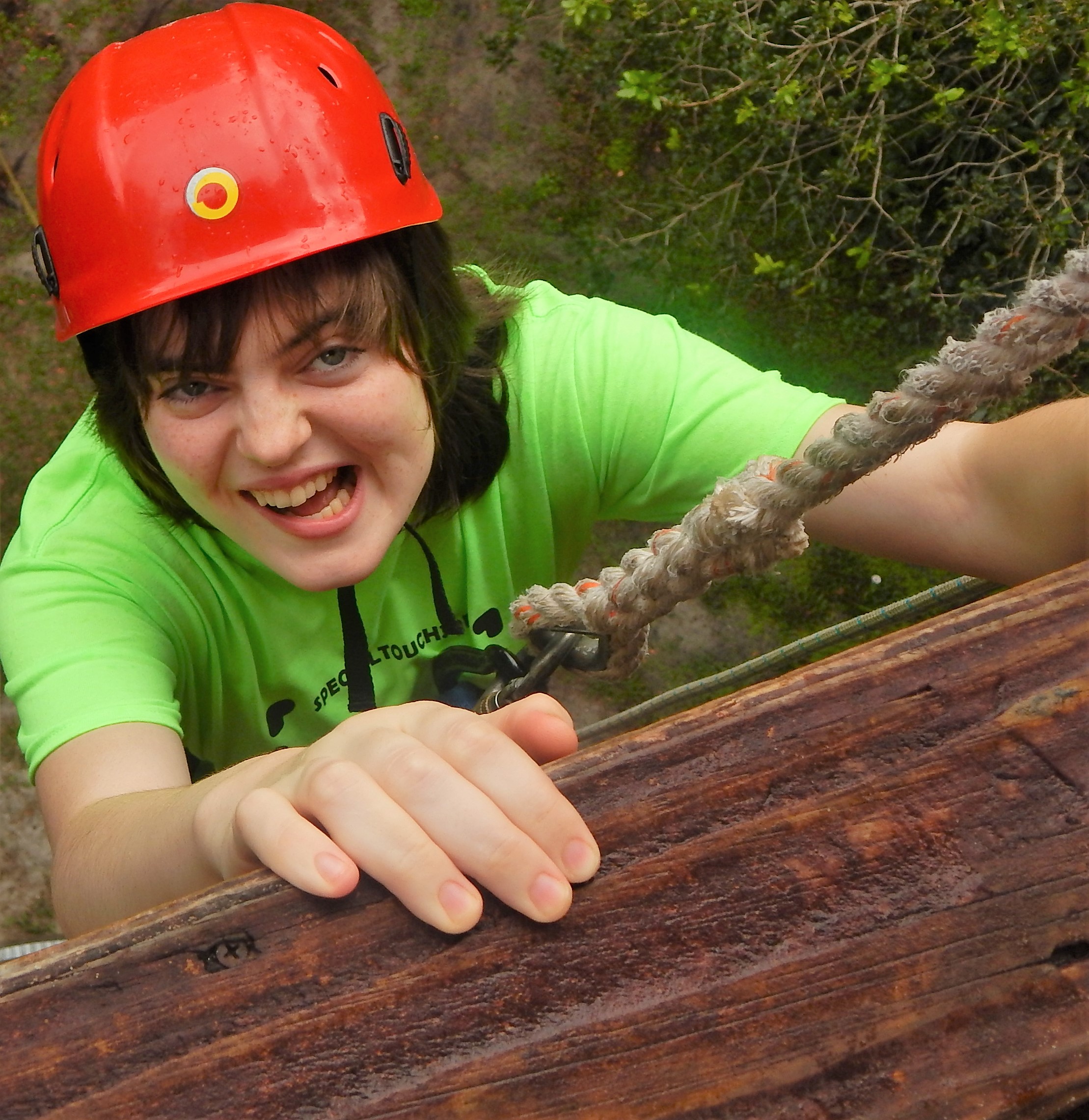 girl climbing wall with rope attached